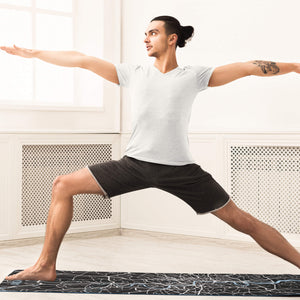 Man doing warrior yoga pose on personalized yoga mat